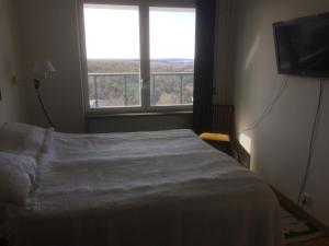 a bedroom with a bed and a large window at Snäck Apartment floor 11 sea view in Visby