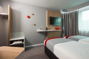a hotel room with two beds and a tv at Holiday Inn Express Ramsgate – Minster by IHG in Minster