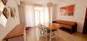 a living room with a table and a couch at Granada Apartments Familiar Deluxe in Portinatx