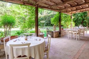 einen Tisch für eine Mahlzeit unter einem Pavillon in der Unterkunft Locanda Quattro Vesta in San Casciano dei Bagni