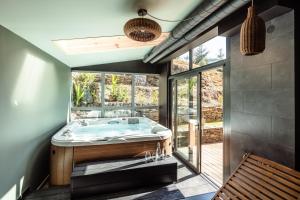 a bathroom with a tub and a large window at Villa Cam In Ski in Duszniki Zdrój