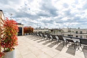 une rangée de chaises sur le toit d'un bâtiment dans l'établissement Nemea Appart Hotel Paris Levallois, à Levallois-Perret