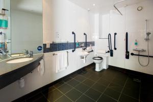 a bathroom with two sinks and a toilet and a shower at Holiday Inn Express Ramsgate – Minster by IHG in Minster