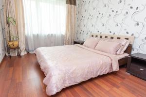 um quarto com uma cama grande e uma colcha branca em Studiominsk 15 Apartments em Minsk