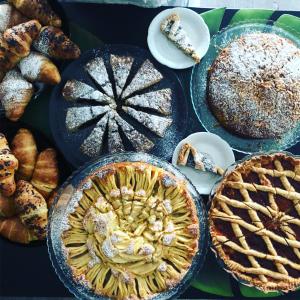 a table topped with pies and other baked goods at Hotel Aplo - Breakfast Experience in Cervia