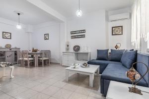 a living room with a blue couch and a table at Thimisi in Skopelos Town
