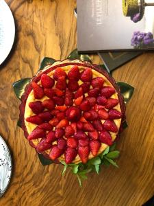 une tarte avec des fraises au-dessus d'une table en bois dans l'établissement Hotel Aplo - Breakfast Experience, à Cervia