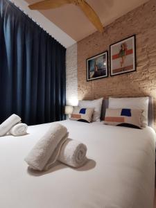 sypialnia z dużym białym łóżkiem z ręcznikami w obiekcie Pink Pigeon w Antwerpii