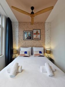 a bedroom with a large white bed with two white pillows at SHWAY - The Pink Pigeon in Antwerp