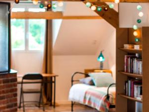 a bedroom with a bed and a book shelf at Laiterie de Tocqueville in Tocqueville