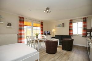 a kitchen and living room with a table and chairs at Strandvilla Krabbe Wohnung 08 in Boltenhagen