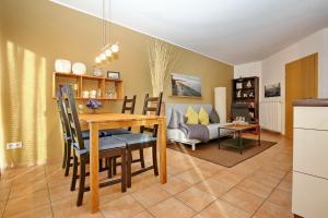 a dining room and living room with a table and chairs at Malaga Wohnung 7 in Boltenhagen