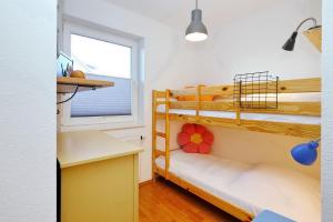 a bedroom with two bunk beds and a desk at Malaga Wohnung 7 in Boltenhagen