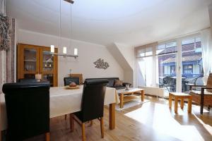 a living room with a table and chairs and a dining room at Papillon Wohnung 02-8 in Boltenhagen
