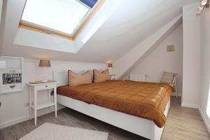 a bedroom with a bed and a skylight at Papillon Wohnung 02-8 in Boltenhagen