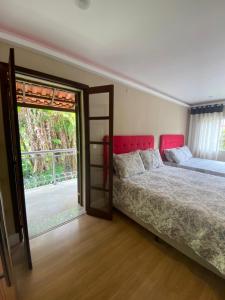 a bedroom with a bed and a sliding glass door at Aconchego Serra Imperial - Suítes in Petrópolis