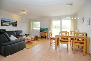 a living room with a couch and a dining room table at Malaga Wohnung 3 in Boltenhagen