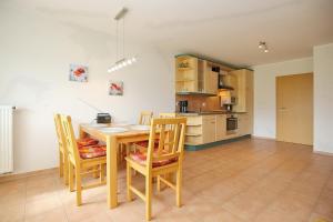 a kitchen and dining room with a wooden table and chairs at Malaga Wohnung 3 in Boltenhagen