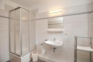 a white bathroom with a sink and a shower at Strandvilla Krabbe Wohnung 12 in Boltenhagen