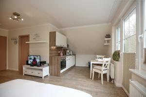 a room with a kitchen with a bed and a table at Strandvilla Krabbe Wohnung 14 in Boltenhagen +8 photos