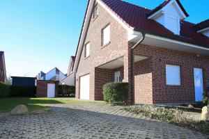 a brick house with a brick driveway at Sanddornweg Wohnung 13 b in Boltenhagen