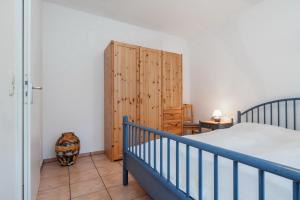 - une chambre avec un lit et une armoire en bois dans l'établissement Dünenblick Wohnung 19, à Boltenhagen