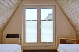 a room with two beds and a window at An der Steilküste Finnhütte 04 in Boltenhagen