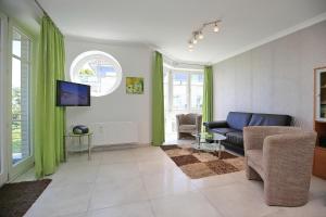 a living room with a couch and a tv at Dünenblick Wohnung 27 in Boltenhagen