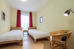 a room with two beds and a window with red curtains at Dünenblick Wohnung 35 in Boltenhagen