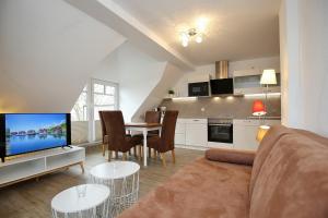 een woonkamer met een bank en een tafel met een tv bij Villa Triton Wohnung 05 in Boltenhagen