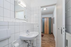 a white bathroom with a sink and a mirror at Dünenblick Wohnung 48 in Boltenhagen