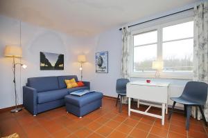 a living room with a blue couch and a table at Dünenblick Wohnung 49 in Boltenhagen