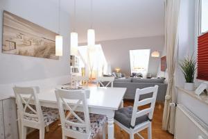 a white dining room with a white table and chairs at Sünnslag Ostsee-Perle Wohnung 044 in Boltenhagen