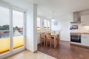 a kitchen and dining room with a table and chairs at Dünenblick Wohnung 53 in Boltenhagen