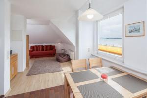 a living room with a red couch and a large window at Dünenblick Wohnung 53 in Boltenhagen