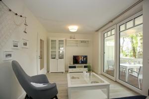 sala de estar con silla y mesa en Strandvilla Scholle - Hering Wohnung 03 en Boltenhagen