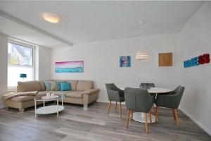 a living room with a couch and a table and chairs at Sünnslag Wohnung 063 in Boltenhagen