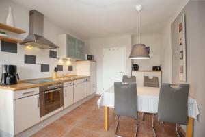a kitchen with a table and chairs in a room at Malaga Wohnung 1 in Boltenhagen