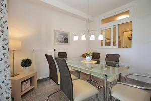 a dining room with a glass table and chairs at Strandvilla Niklot Wohnung 03 in Boltenhagen