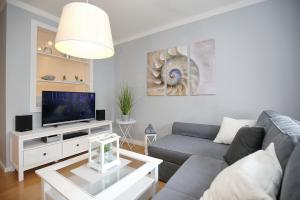 a living room with a couch and a tv at Sünnslag Wohnung 096 in Boltenhagen