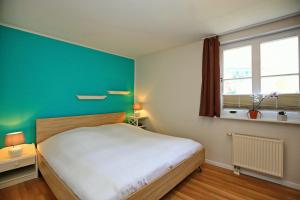 a bedroom with a bed and a green wall at Papillon Wohnung 09-1 in Boltenhagen