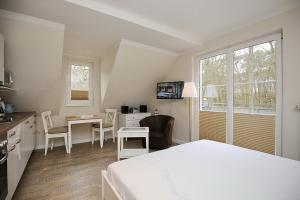 a room with a bed and a kitchen with a table at Strandvilla Krabbe Wohnung 11 in Boltenhagen