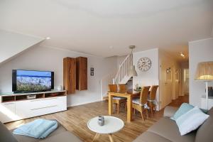 ein Wohnzimmer mit einem Sofa und einem Esszimmer in der Unterkunft Papillon Wohnung 10-6 in Boltenhagen