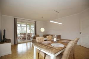 a dining room with a wooden table and chairs at Likedeeler II Wohnung 04 in Boltenhagen