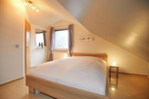 a bedroom with a white bed in a attic at Urlauberdorf Haus 63a in Boltenhagen