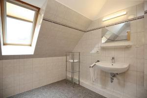ein Bad mit einem Waschbecken und einem Spiegel in der Unterkunft Strandvilla Krabbe Wohnung 13 in Boltenhagen