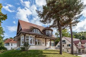 ein Haus mit einem Baum davor in der Unterkunft Strandvilla Krabbe Wohnung 13 in Boltenhagen