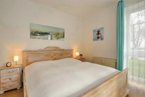 a bedroom with a white bed and a window at Dünenblick Wohnung 05 in Boltenhagen