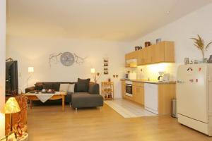 a kitchen and a living room with a couch and a refrigerator at Dünenblick Wohnung 05 in Boltenhagen