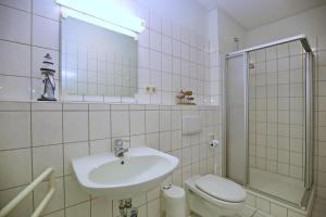 a bathroom with a sink and a toilet and a mirror at Dünenblick Wohnung 34 in Boltenhagen